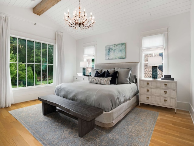 bedroom with multiple windows, lofted ceiling with beams, light hardwood / wood-style floors, and an inviting chandelier