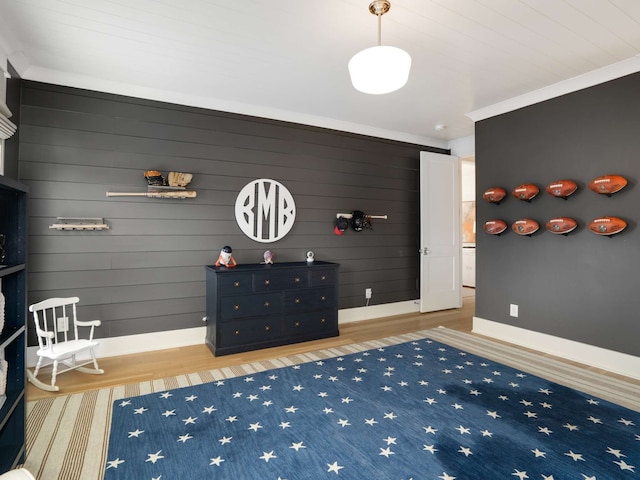 interior space featuring wood walls, wood-type flooring, and ornamental molding