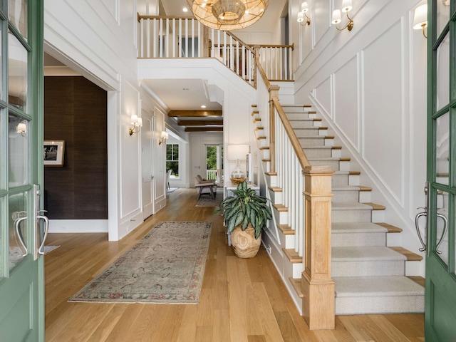 entrance foyer with light wood-type flooring and a towering ceiling