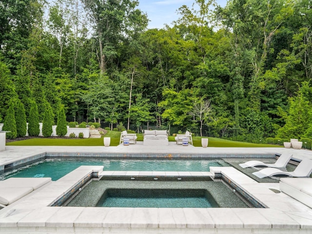 view of swimming pool with a lawn and an in ground hot tub