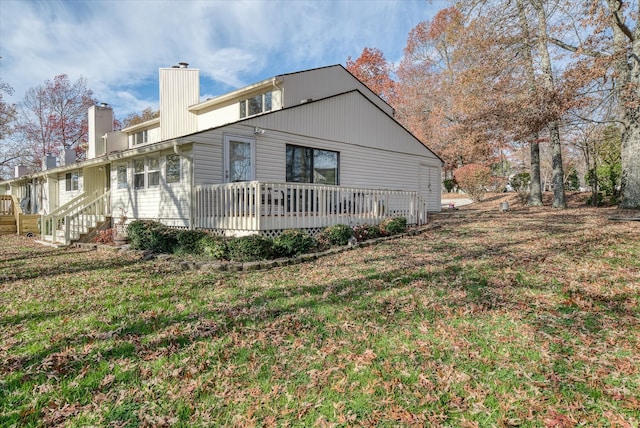 rear view of house with a deck and a lawn