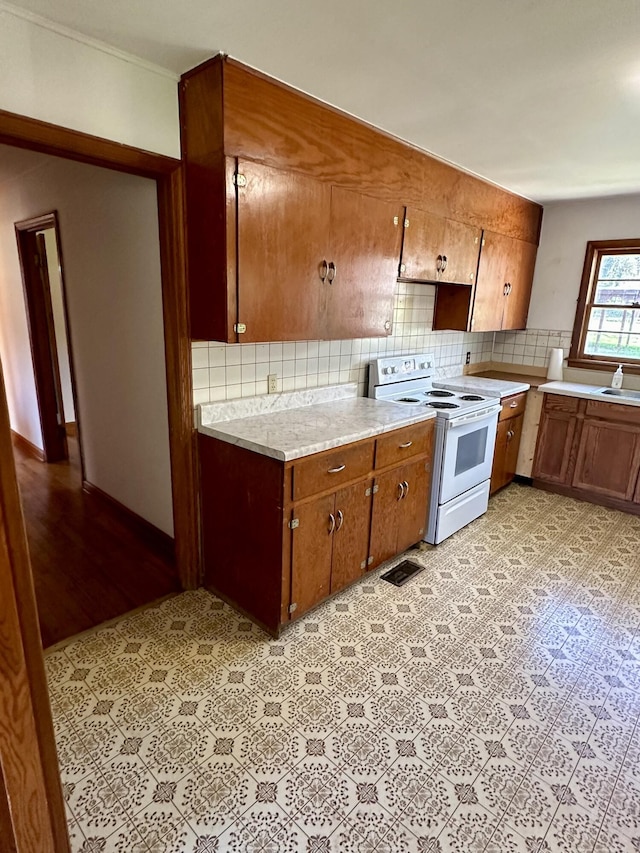 kitchen featuring backsplash and white range with electric stovetop