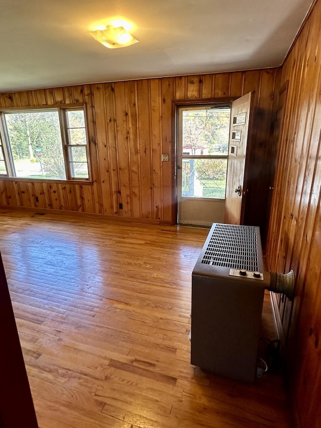 unfurnished room featuring wood walls and light hardwood / wood-style floors