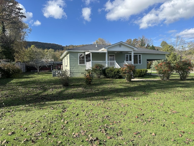 view of front of property with a carport, covered porch, and a front lawn