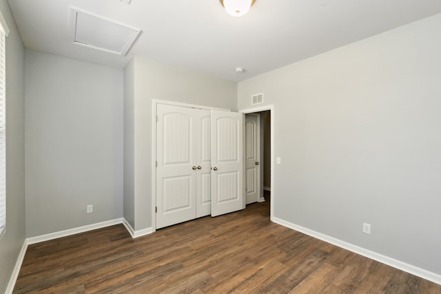 unfurnished bedroom with a closet and dark wood-type flooring