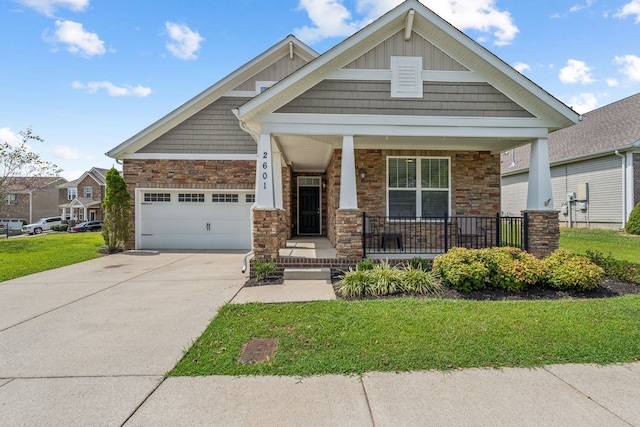 craftsman house with a garage, a porch, and a front yard