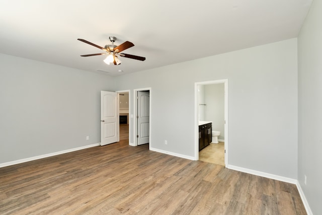 unfurnished bedroom featuring ceiling fan, light hardwood / wood-style floors, and ensuite bath