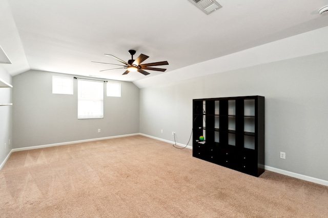 interior space with ceiling fan, light colored carpet, and lofted ceiling