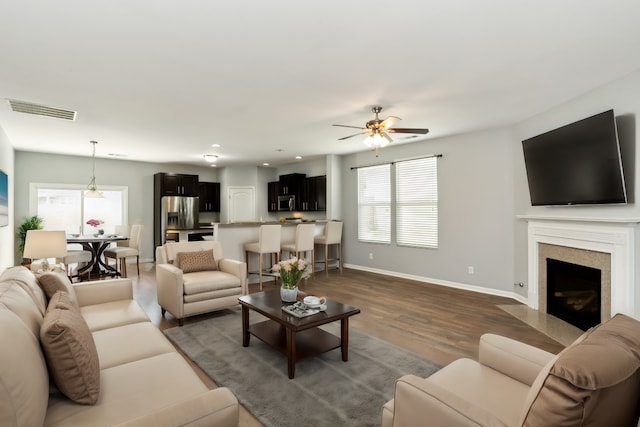 living room with dark hardwood / wood-style floors and ceiling fan