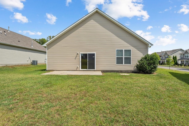 back of property with a lawn, a patio area, and central air condition unit