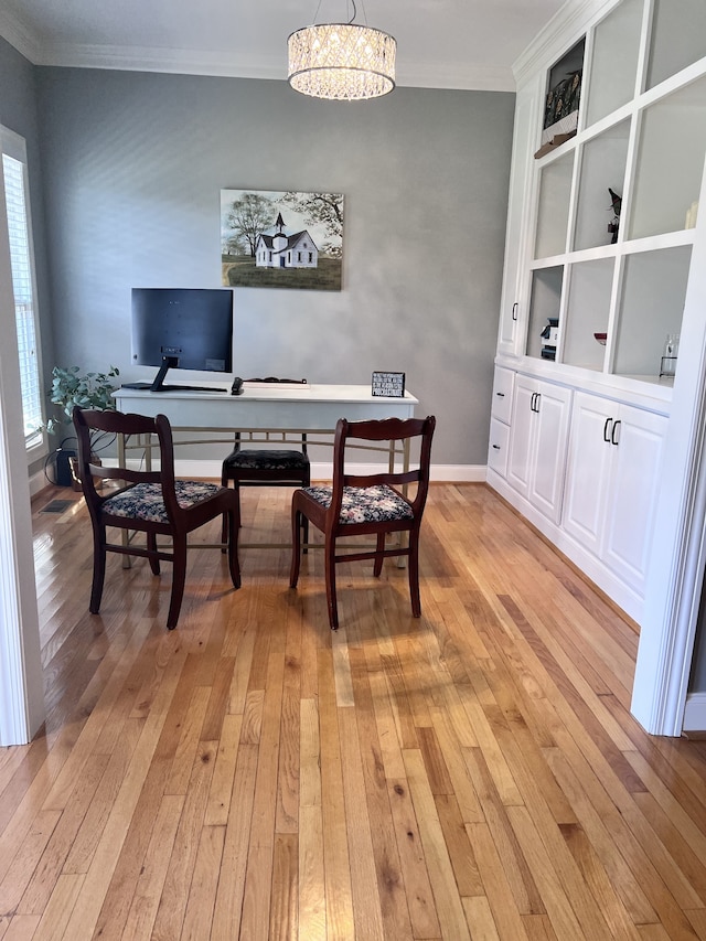 dining area with a chandelier, light hardwood / wood-style flooring, and ornamental molding