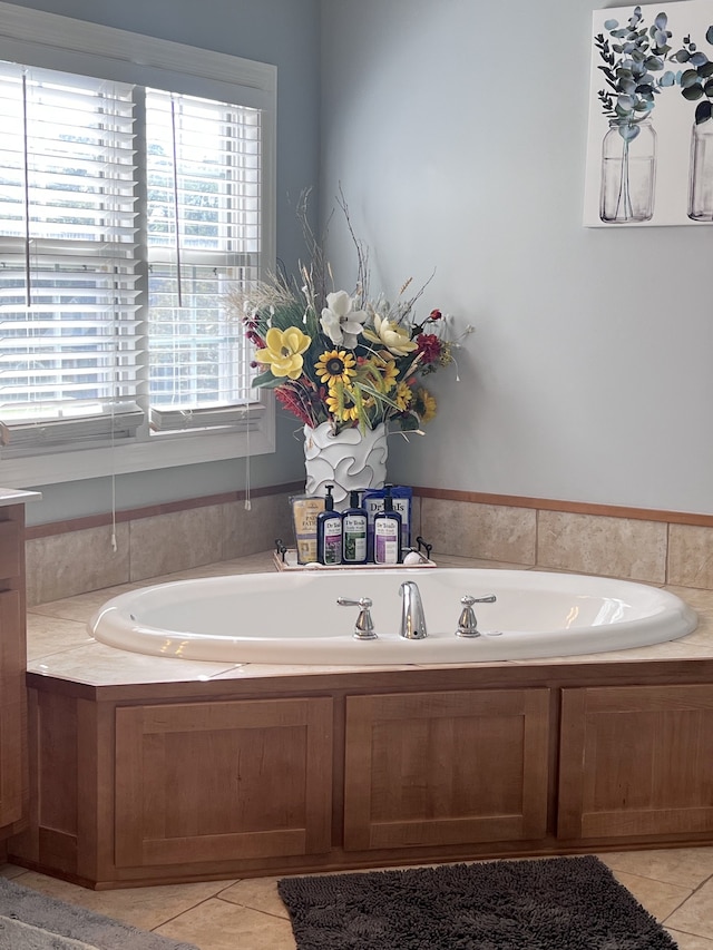 bathroom with tile patterned floors and a relaxing tiled tub