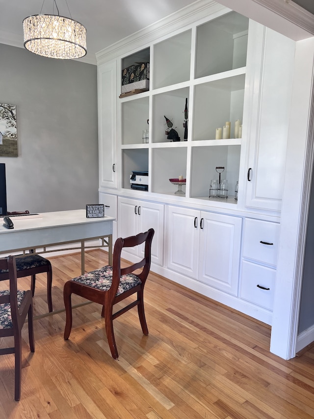 office area with light hardwood / wood-style floors, crown molding, and a chandelier