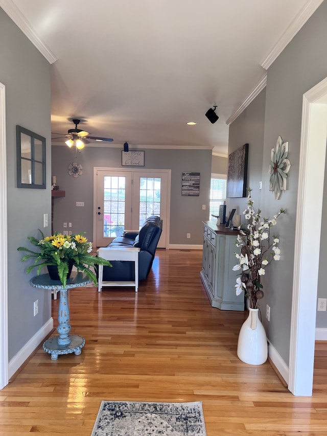 living room featuring crown molding, french doors, ceiling fan, and light wood-type flooring