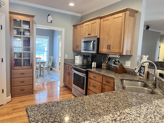 kitchen featuring crown molding, sink, appliances with stainless steel finishes, and light hardwood / wood-style flooring