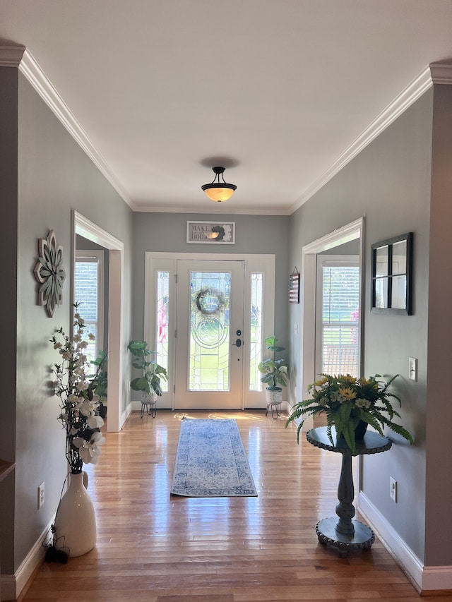 entrance foyer with ornamental molding and light wood-type flooring