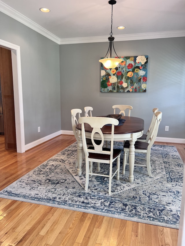 dining area with hardwood / wood-style floors and ornamental molding