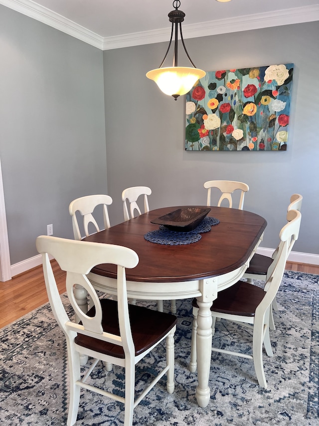 dining space featuring hardwood / wood-style floors and ornamental molding