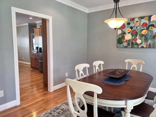 dining room with light hardwood / wood-style floors and ornamental molding