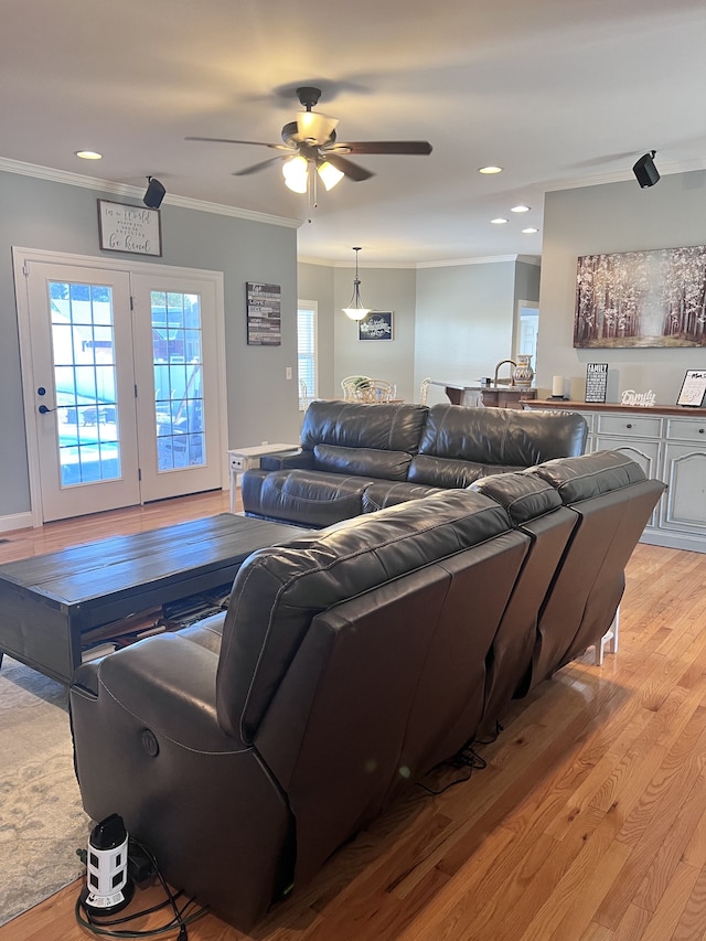 living room featuring light hardwood / wood-style flooring, ceiling fan, and ornamental molding