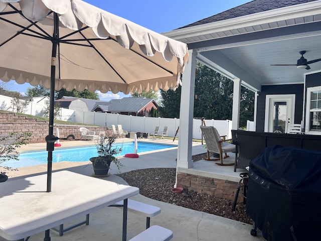 view of swimming pool with ceiling fan, a patio, and grilling area