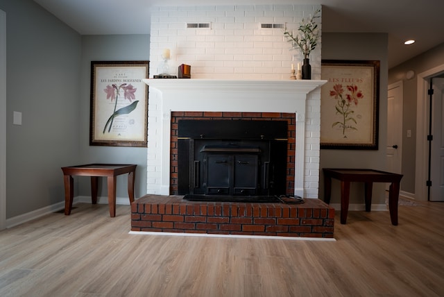 interior details featuring hardwood / wood-style floors and a brick fireplace