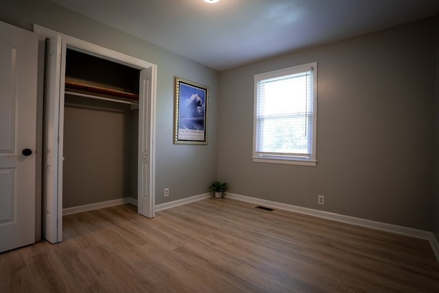 unfurnished bedroom featuring hardwood / wood-style flooring and a closet