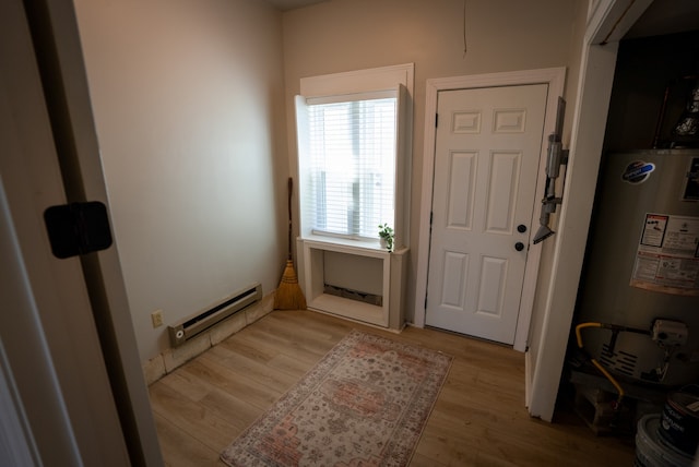 entrance foyer featuring water heater, light hardwood / wood-style floors, and a baseboard heating unit