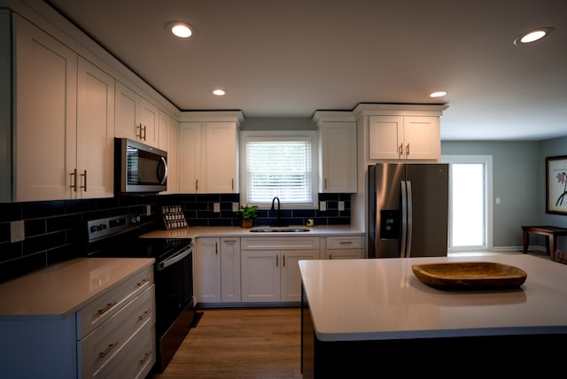 kitchen featuring tasteful backsplash, white cabinetry, sink, and appliances with stainless steel finishes