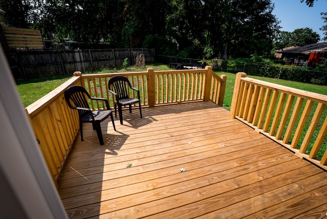 wooden terrace featuring a lawn