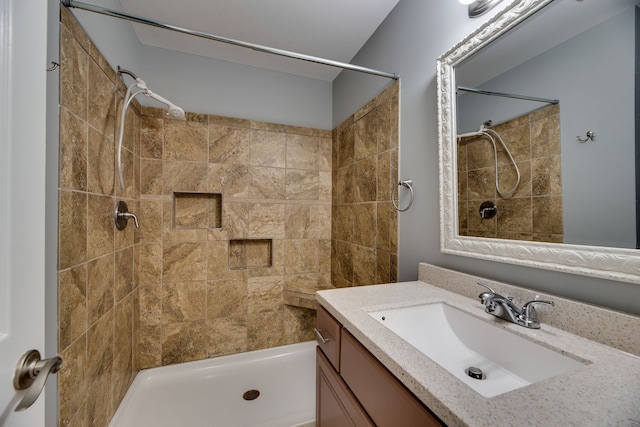 bathroom with vanity and tiled shower