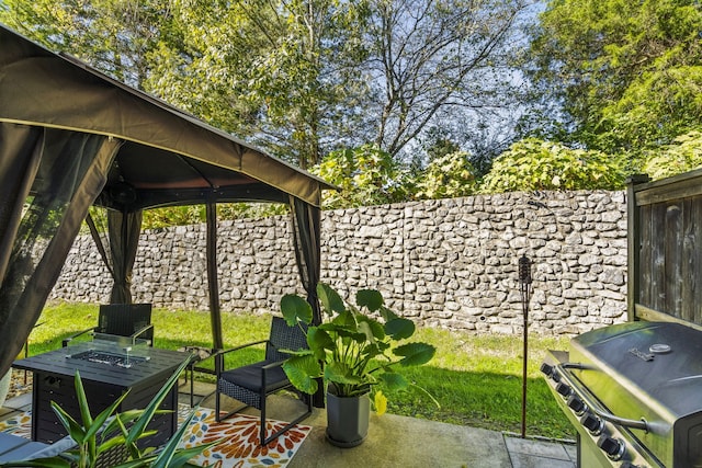 view of patio with a gazebo, a fire pit, and a grill