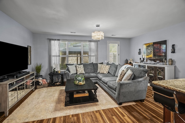 living room with wood-type flooring and a notable chandelier