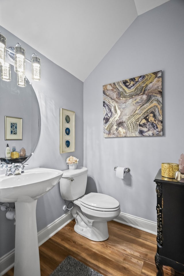 bathroom featuring hardwood / wood-style flooring, toilet, and vaulted ceiling