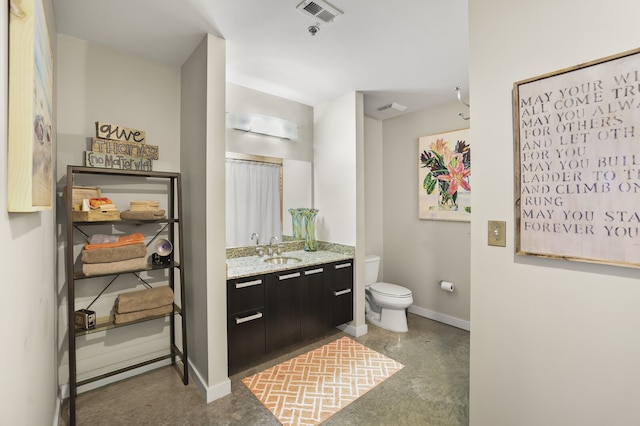 bathroom with concrete flooring, vanity, and toilet