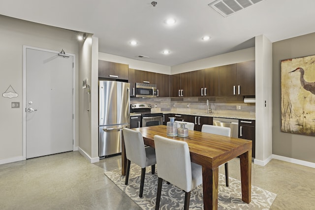 kitchen featuring backsplash, dark brown cabinets, stainless steel appliances, and sink