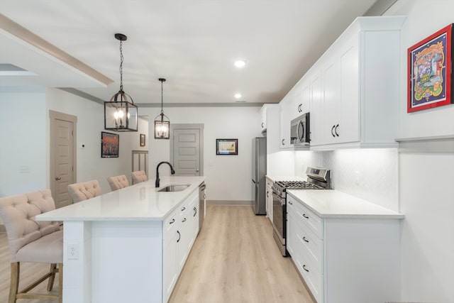 kitchen with a breakfast bar, stainless steel appliances, a center island with sink, and sink