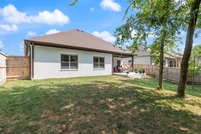 back of house with a yard and a patio