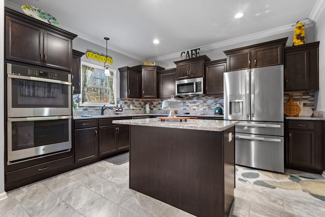 kitchen featuring stainless steel appliances, crown molding, pendant lighting, and backsplash