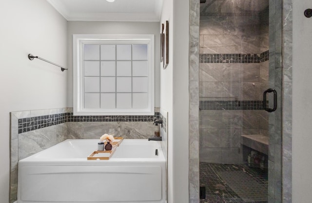 bathroom with ornamental molding and shower with separate bathtub