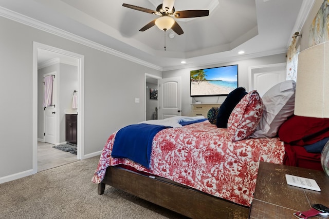 carpeted bedroom with crown molding, ceiling fan, a raised ceiling, and ensuite bath