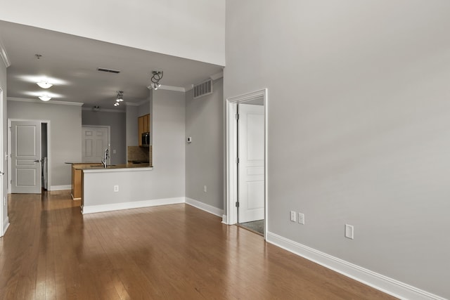 unfurnished living room with wood-type flooring and ornamental molding