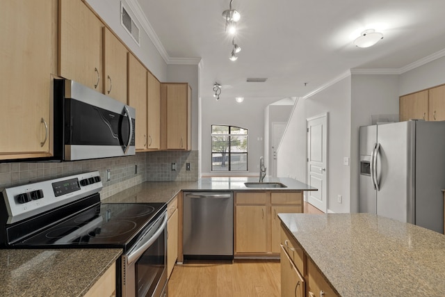 kitchen featuring appliances with stainless steel finishes, light wood-type flooring, ornamental molding, sink, and stone countertops