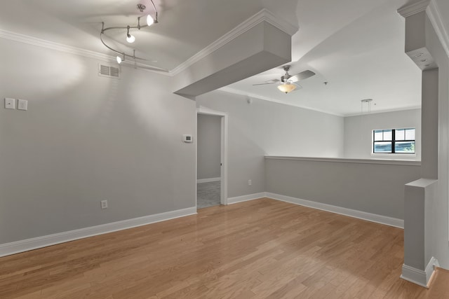 spare room with light wood-type flooring, ceiling fan, and ornamental molding