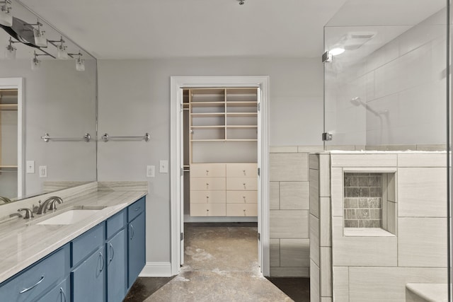 bathroom with vanity, a shower with door, and concrete floors