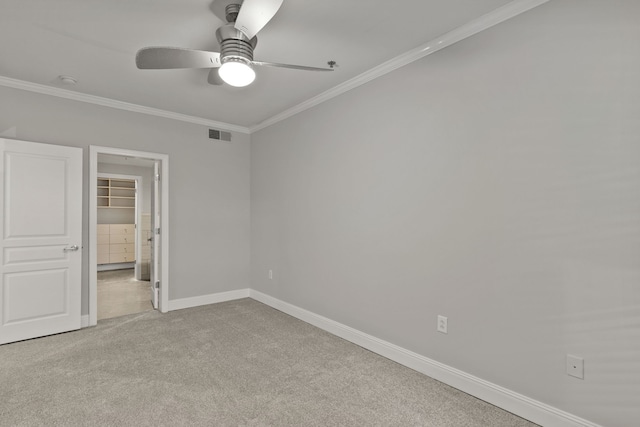 spare room featuring ceiling fan, ornamental molding, and light carpet