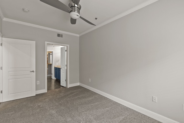 unfurnished bedroom with dark carpet, ensuite bath, ceiling fan, and ornamental molding