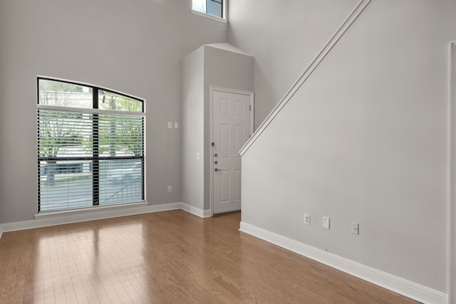 interior space with light wood-type flooring and a high ceiling