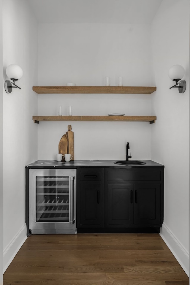 bar featuring dark hardwood / wood-style flooring, beverage cooler, and sink