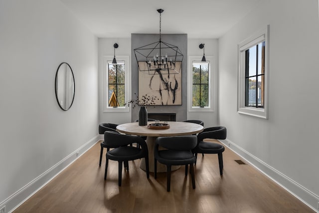 dining area with a notable chandelier and hardwood / wood-style flooring